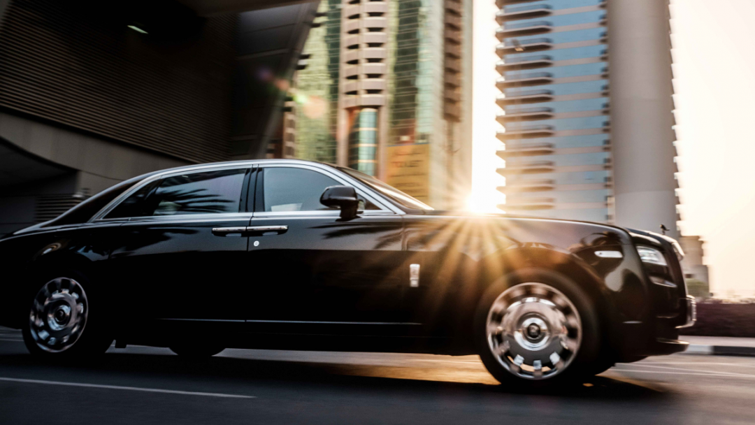 chauffeur-services-car-driving-through-city-sun-shining