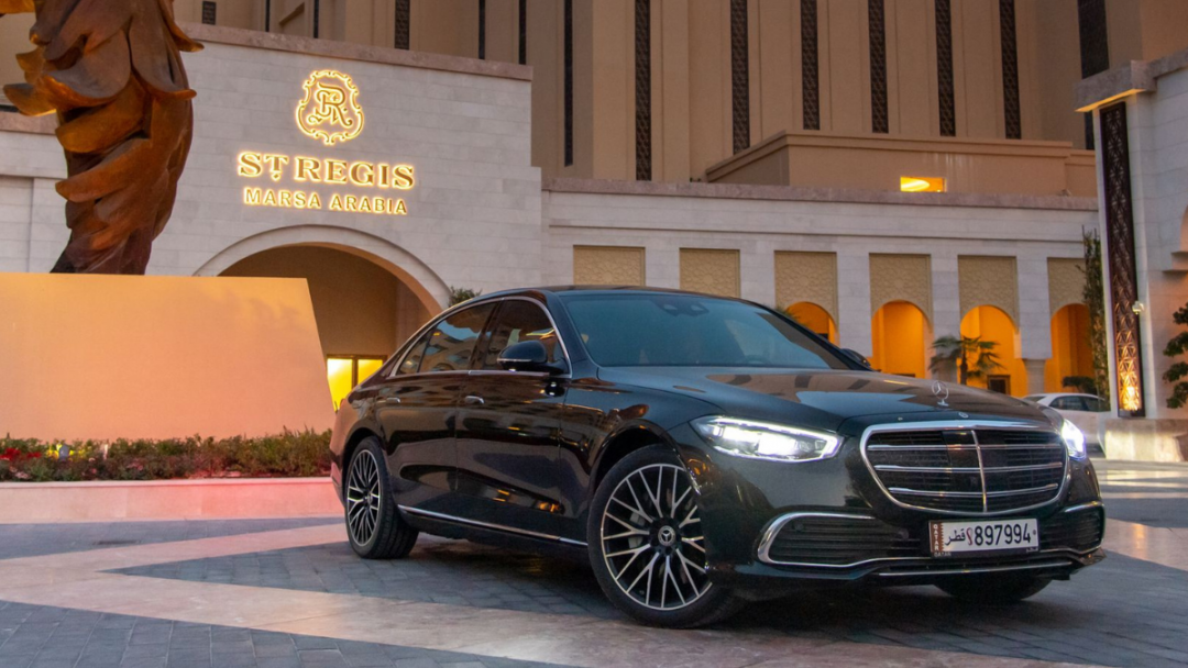 Front view of a black Mercedes-Benz S-Class in front of the St Regis Hotel in Doha, Qatar