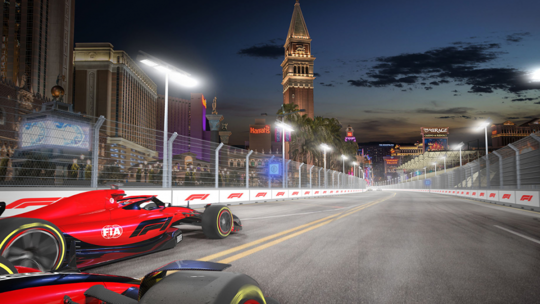 View of Formula 1 Las Vegas track with a red and black car and a famous landmark in the background at night