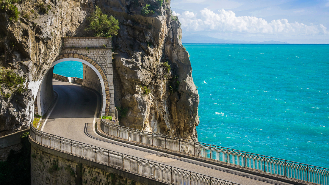 winding road along the amalfi coastal route, with crystal blue sea